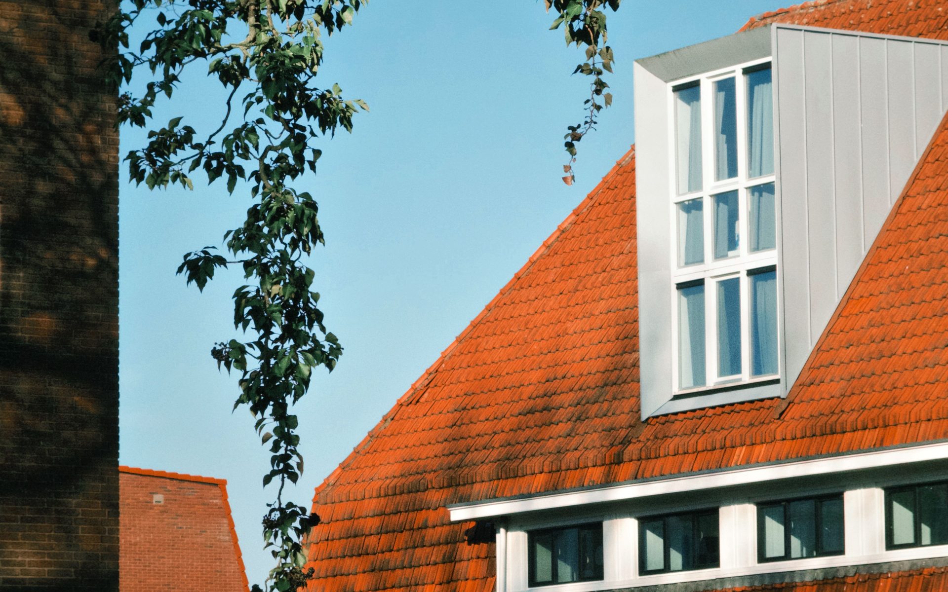 Metallverkleideter Dachaufbau mit hohem Fenster auf dem Satteldach eines Reihenhauses